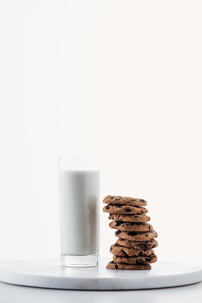 lait frais en verre près de biscuits au chocolat sur support en marbre isolé sur blanc
 - Photo, image