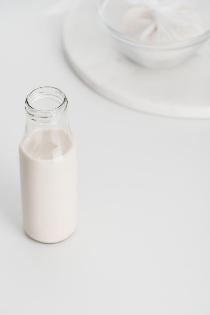 селективный фокус рисового молока в бутылке с рисом на заднем плане
 - Фото, изображение