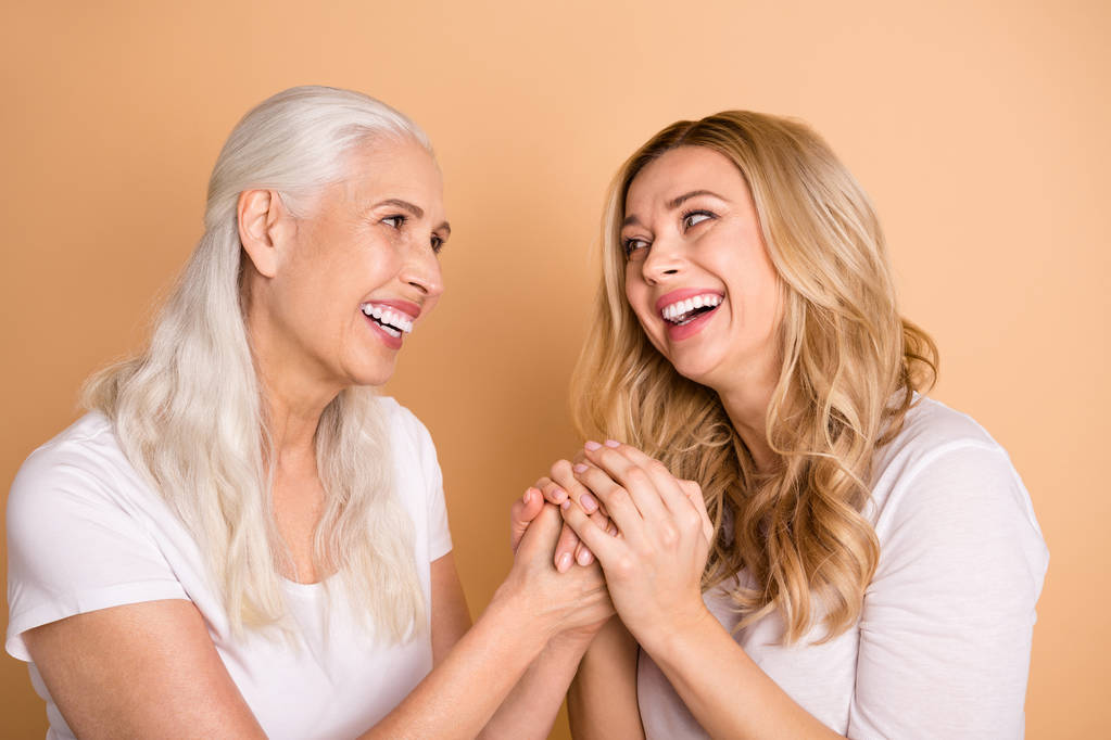 Close-up portrait of nice-looking winsome sweet tender gentle attractive charming cheerful cheery dreamy ladies holding hands trust isolated over beige pastel background - Photo, Image