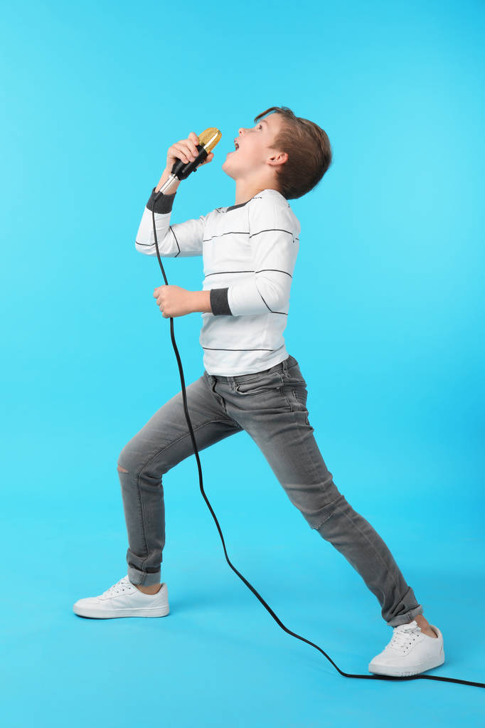 Lindo niño cantando en micrófono sobre fondo de color
 - Foto, imagen