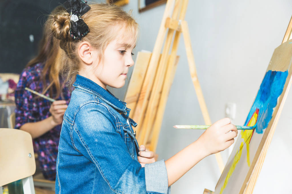 kislány egy tanár csoport óvodáskorú hallgató ült a rajz egy képet. Festés maelbert, paletta és festékek. Vissza az iskolába és az oktatás koncepcióba. - Fotó, kép