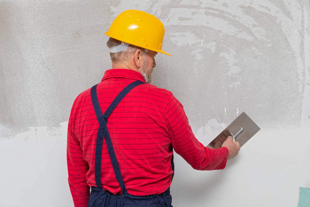 Trabajador senior llenando las paredes
 - Foto, Imagen
