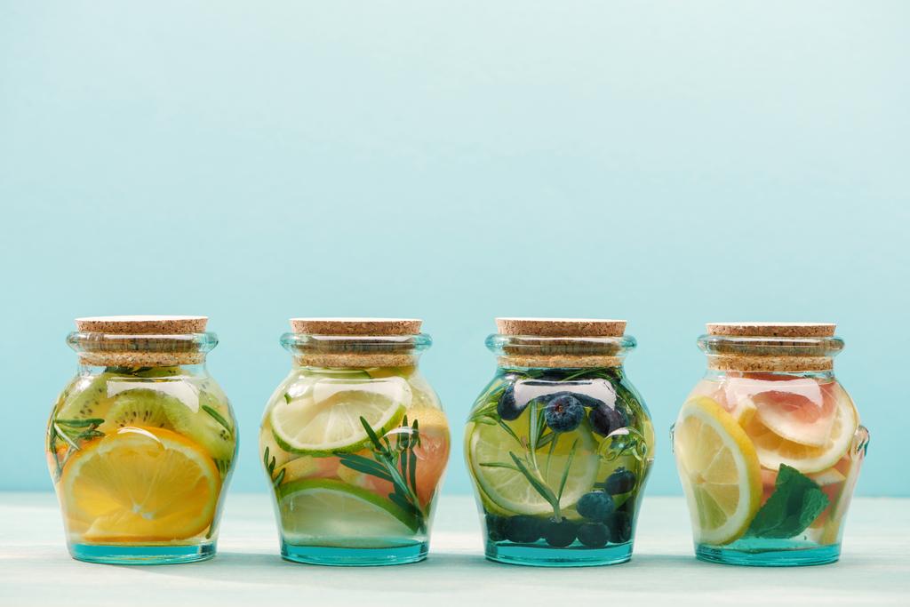 mavi üzerinde izole meyve ve otlar ile kavanozlarda taze Detox İçecekler - Fotoğraf, Görsel