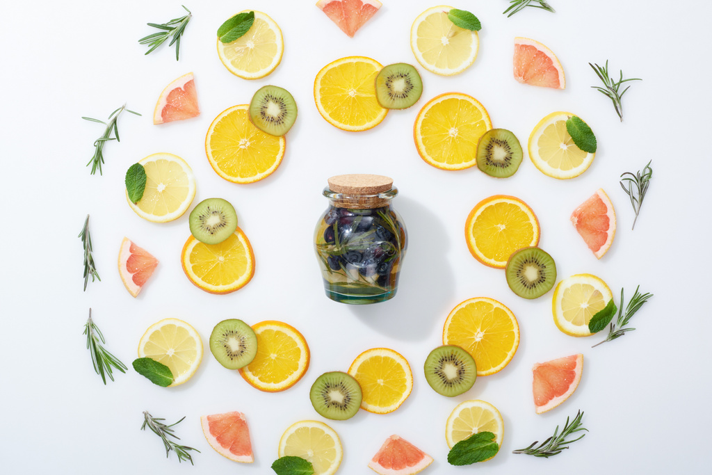Flat Lay με φέτες ακτινίδιο, πορτοκάλια, λεμόνια, γκρέιπφρουτ, μέντα, δεντρολίβανο και ποτό αποτοξίνωσης σε βάζο  - Φωτογραφία, εικόνα