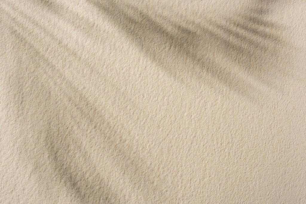 影とコピースペースでベージュの砂の背景のトップビュー - 写真・画像