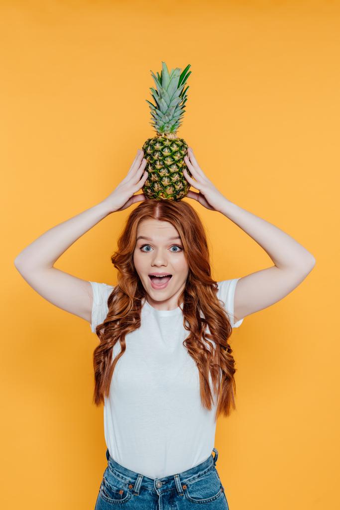 iloinen punapää tyttö katselee kameraa ja poseeraa ananas pään eristetty keltainen
 - Valokuva, kuva