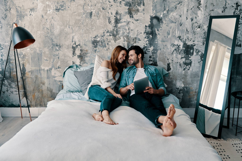belo jovem casal usando tablet digital enquanto passa o tempo na cama em casa
               - Foto, Imagem