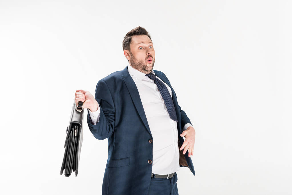 überraschte übergewichtige Geschäftsmann in engen formalen tragen Aktentasche isoliert auf weiß - Foto, Bild