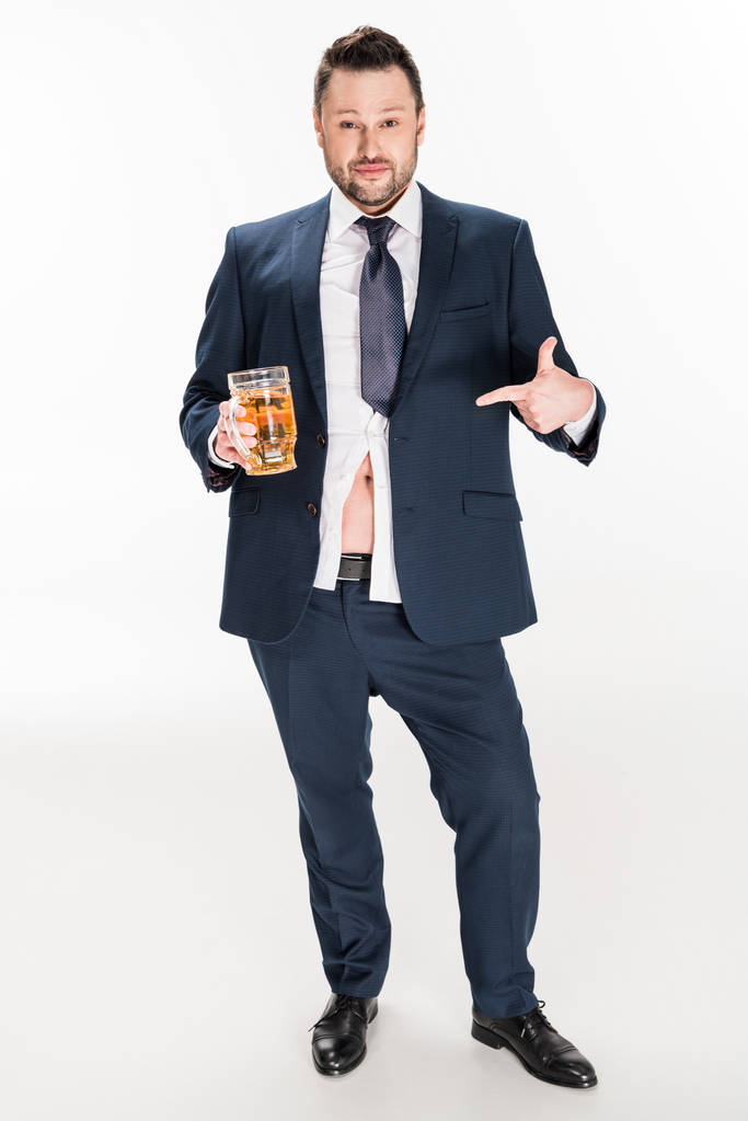 hombre con sobrepeso en ropa formal apuntando con el dedo al vaso de cerveza en blanco
 - Foto, Imagen