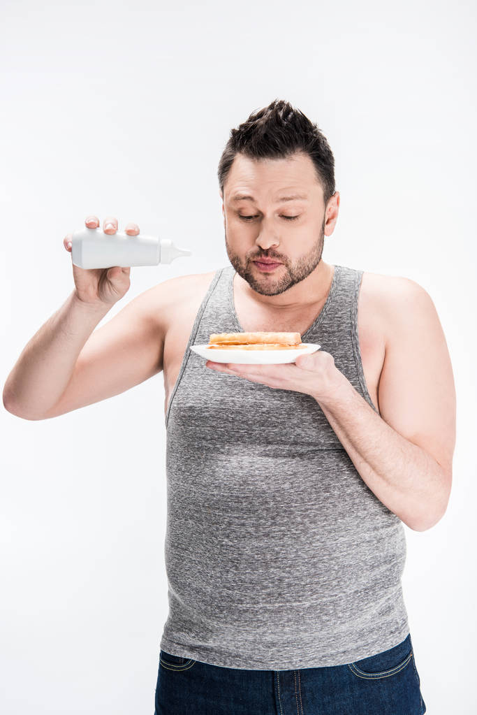 hombre con sobrepeso sosteniendo frasco de jarabe y gofres aislados en blanco
 - Foto, imagen