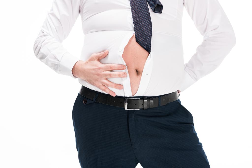 частичный вид человека с избыточным весом в тесной формальной одежде, показывающий живот изолирован на белом
 - Фото, изображение