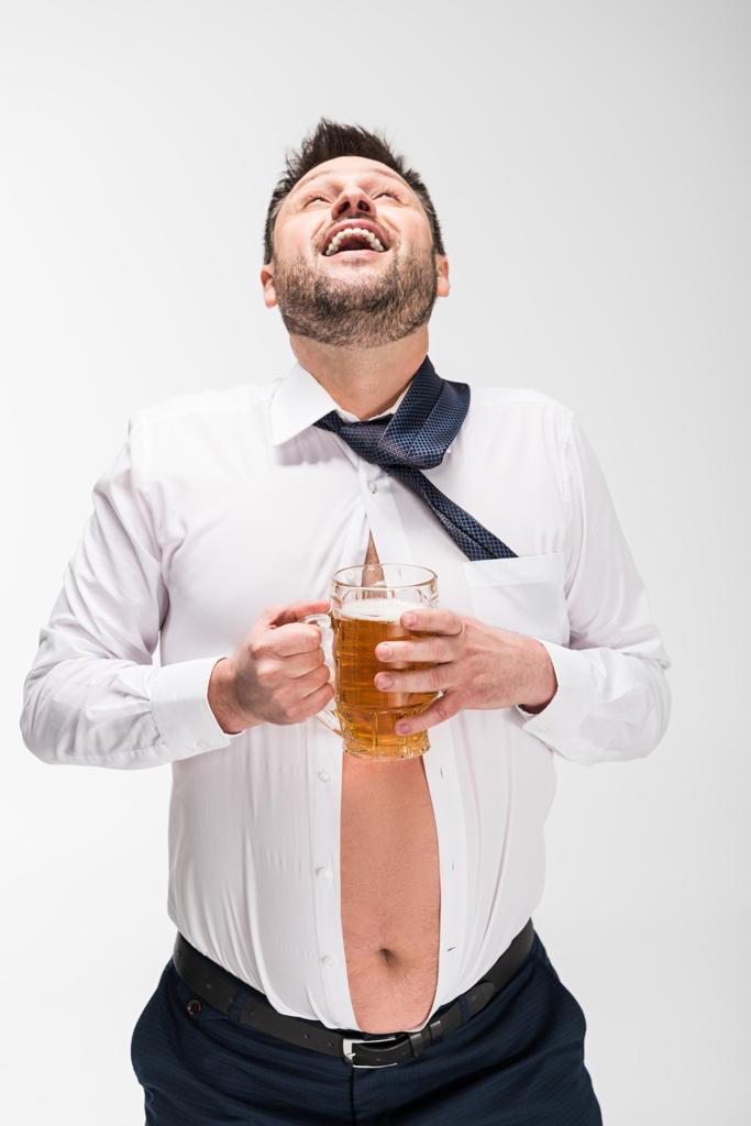 šťastný muž s nadváhou, s těsnou košilí a s skleněným pivem na bílém - Fotografie, Obrázek