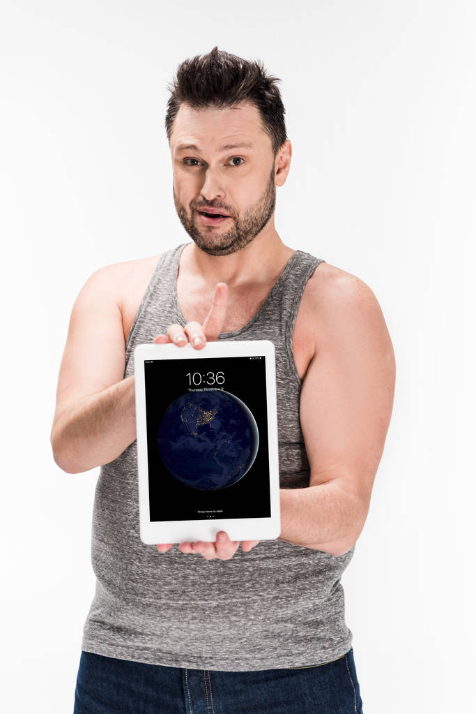 Nadváha muž, který se dívá na fotoaparát a zobrazuje digitální tablet s jablečnou domovskou obrazovkou izolovanou na bílém - Fotografie, Obrázek