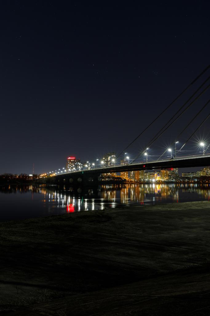 nigth で照らされた建物、橋および川との都市の景観 - 写真・画像
