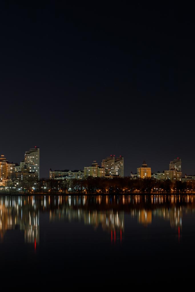 bâtiments éclairés avec réflexion sur l'eau la nuit
 - Photo, image
