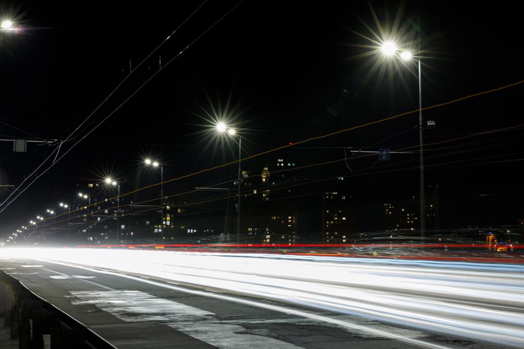 lange blootstelling van lichten op weg bij nacht dichtbij gebouwen - Foto, afbeelding