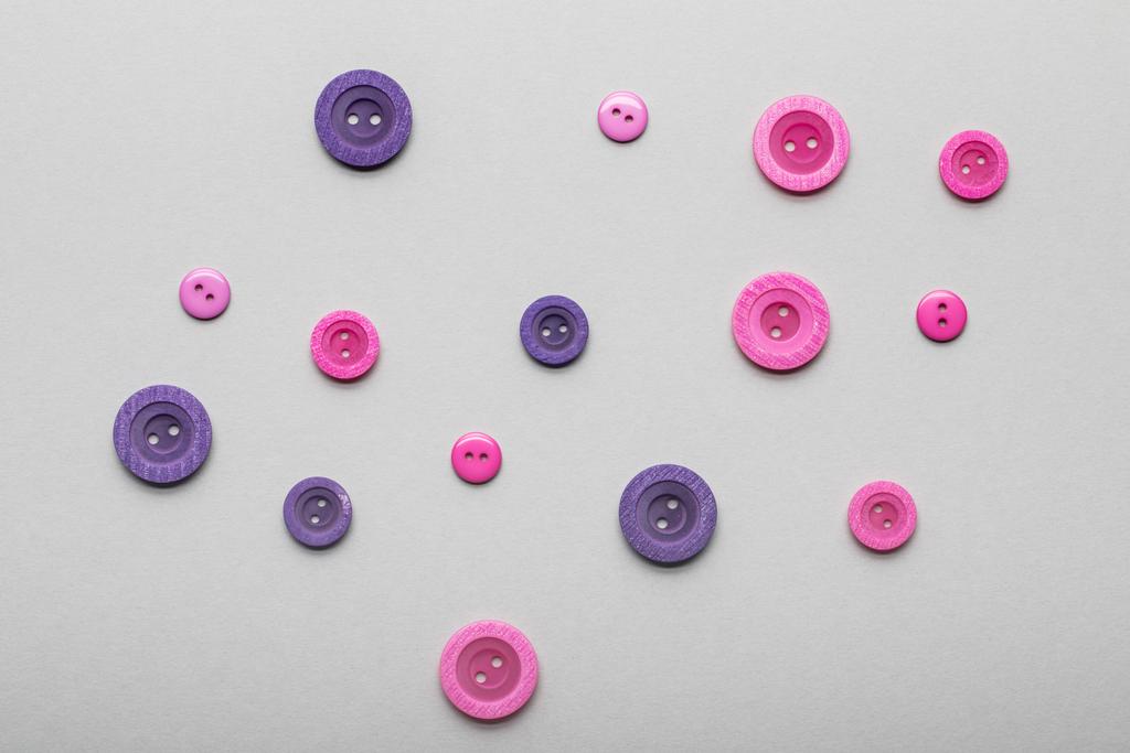 vue de dessus des boutons de vêtements roses et violets isolés sur gris
 - Photo, image