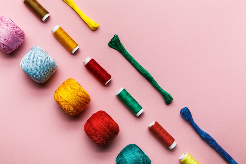 カラフルな編み糸のボール、刺繍糸とピンクのスレッドコイルのトップビュー  - 写真・画像