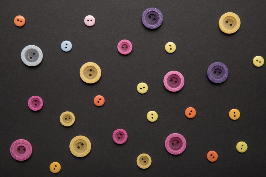 top view of various colorful clothing buttons isolated on black - Photo, Image