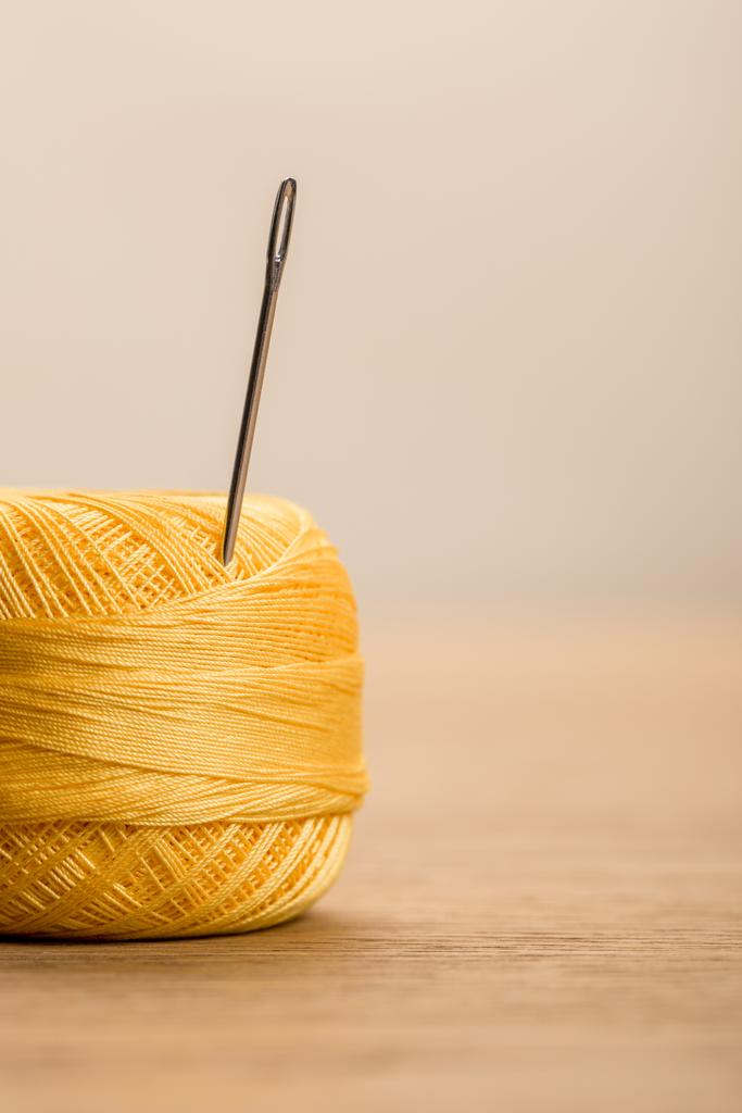 foco seletivo da bola de fio de malha de algodão amarelo com agulha isolada em bege com espaço de cópia
 - Foto, Imagem