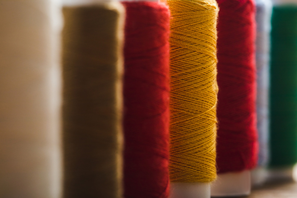 close up view of colorful cotton thread coils in row - Photo, Image