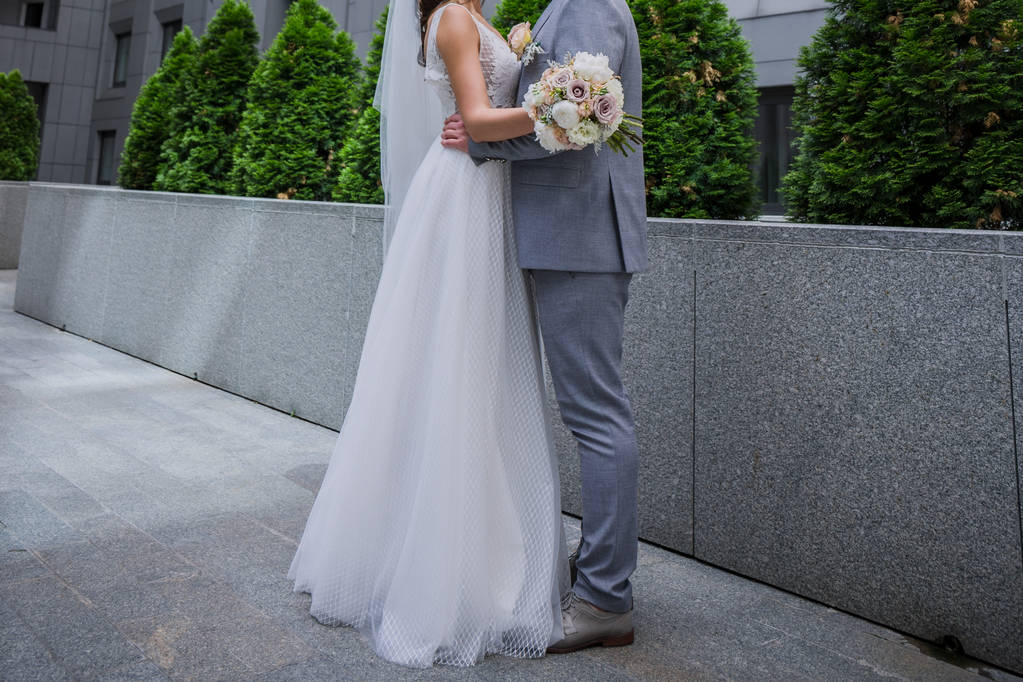 Braut und Bräutigam stehen zusammen in der Nähe des Bürogebäudes. - Foto, Bild