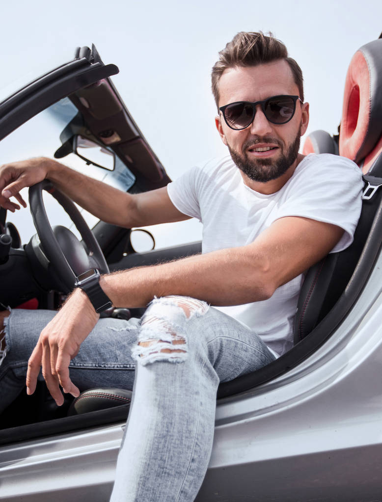 Sluit up.stylish jonge man zitten in een luxeauto - Foto, afbeelding