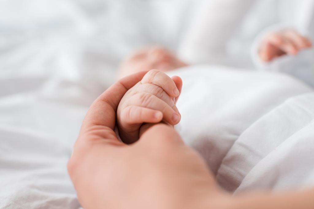 rajattu näkymä äiti ja vauva kädestä
 - Valokuva, kuva