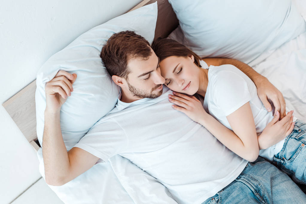 fölött véve az ember átfogó feleség alvás közben ágyban - Fotó, kép