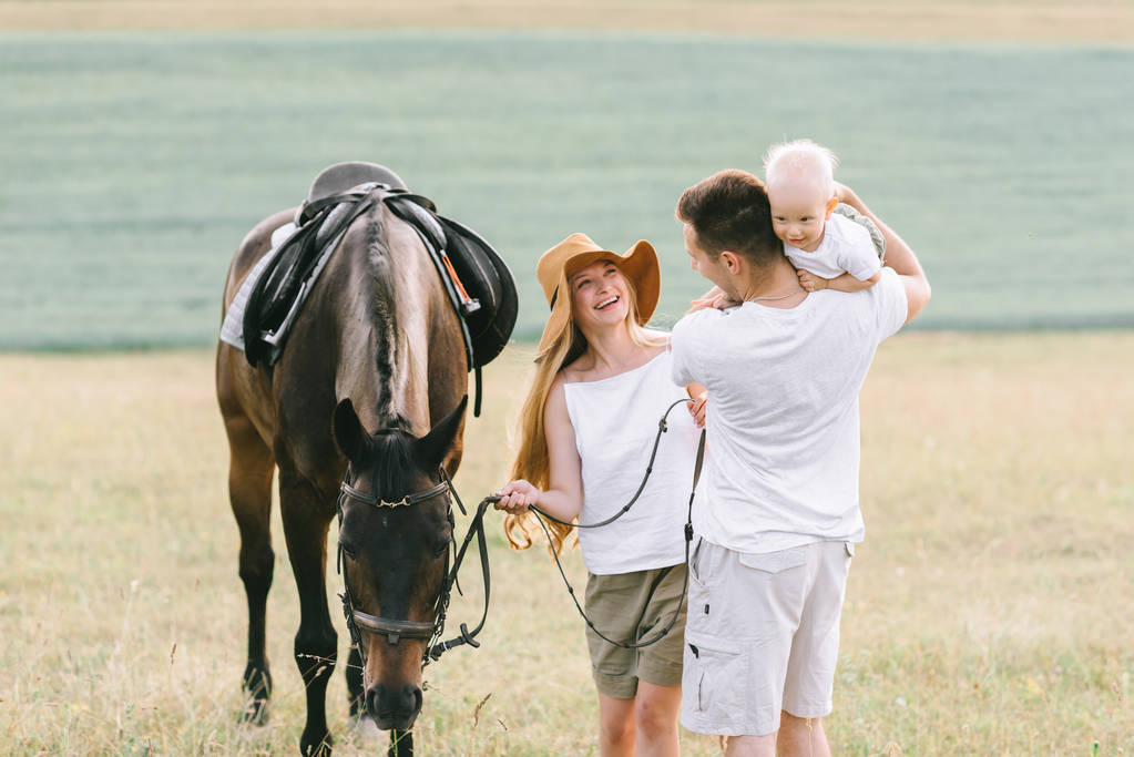 Молодая семья веселится в поле. Родители и ребенок с
 - Фото, изображение