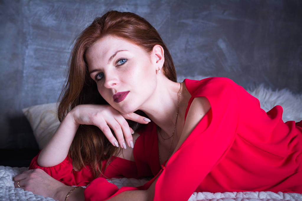 hermosa y sexy mujer con el pelo rojo y vestido con un vestido rojo
 - Foto, imagen