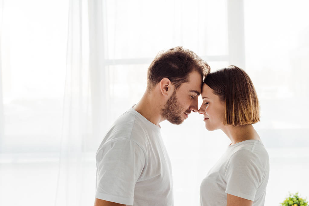 боковой вид счастливой любящей пары, стоящей с закрытыми глазами дома
 - Фото, изображение