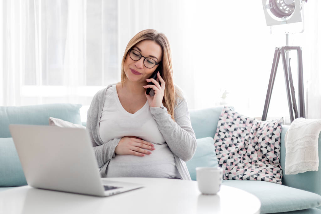 Mujer embarazada que trabaja en línea con el ordenador portátil en casa, concepto freelancing
 - Foto, imagen