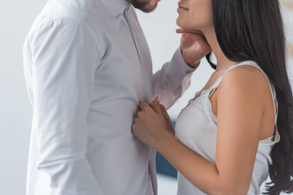 cropped view of brunette woman touching white shirt on boyfriend  - Photo, Image