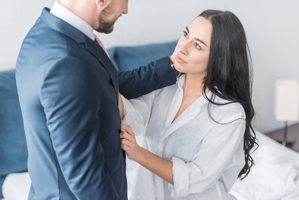 ostříhané zobrazení vousatého muže dotýkat se šťastné bruneté přítelkyně v bílé košili  - Fotografie, Obrázek