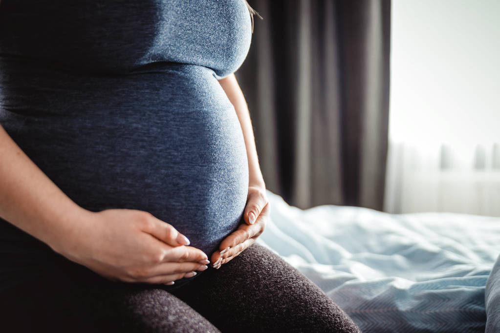 Donna incinta che si tocca la pancia, da vicino sulle mani
 - Foto, immagini