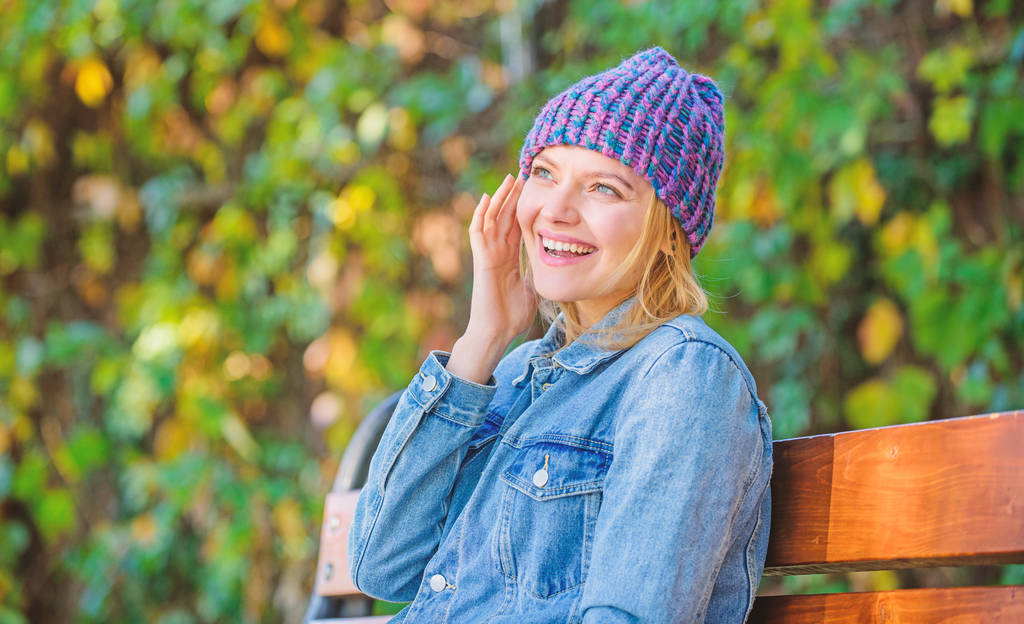 Feel comfortable this fall with soft and warm stylish hat. Knitted accessory for fall season. Autumn fashion accessory. Woman sit bench park nature background. Girl wear knitted hat accessory - Photo, Image