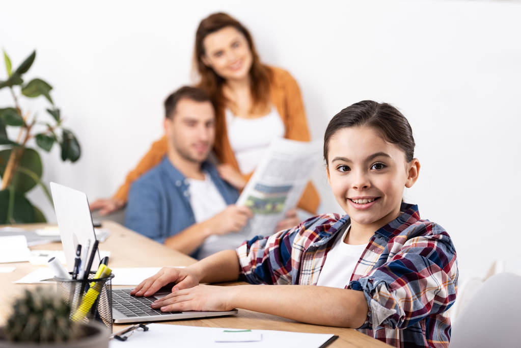 избирательный фокус веселого ребенка с ноутбуком рядом с родителями дома
  - Фото, изображение