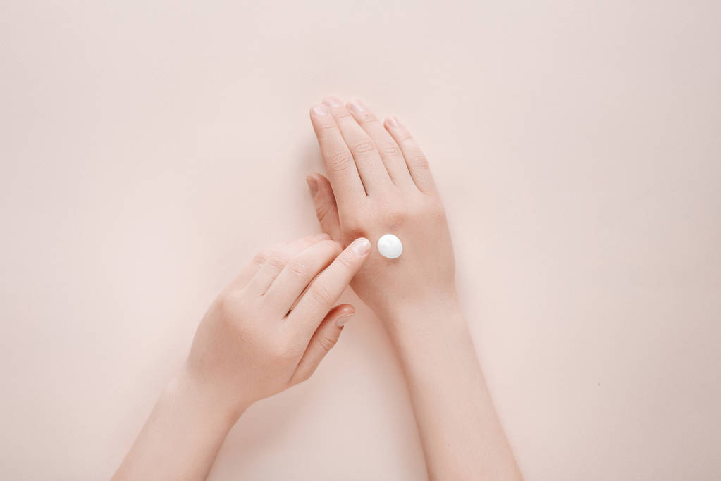 Nainen kosteuttaa kätensä kosmeettisia kerma voide kopioi tilaa beige tausta. Konsepti malli naisellinen blogi, kauneus käsite
 - Valokuva, kuva