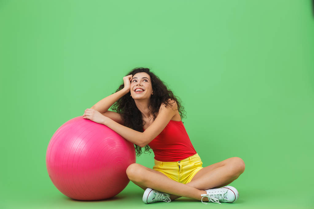 Bild der schönen Frau auf dem Boden sitzend mit Fitnessball duri - Foto, Bild