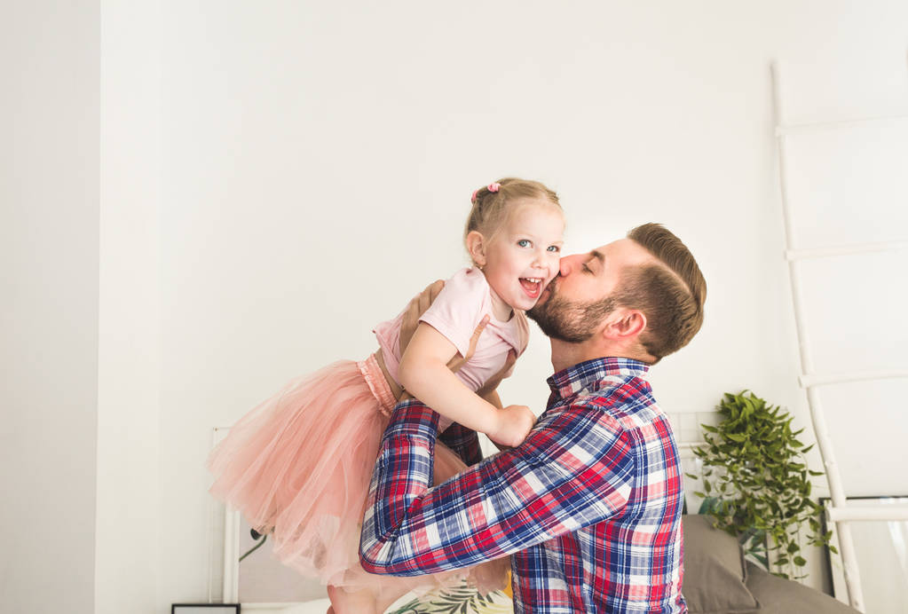 Милая маленькая девочка и ее отец веселятся дома
. - Фото, изображение