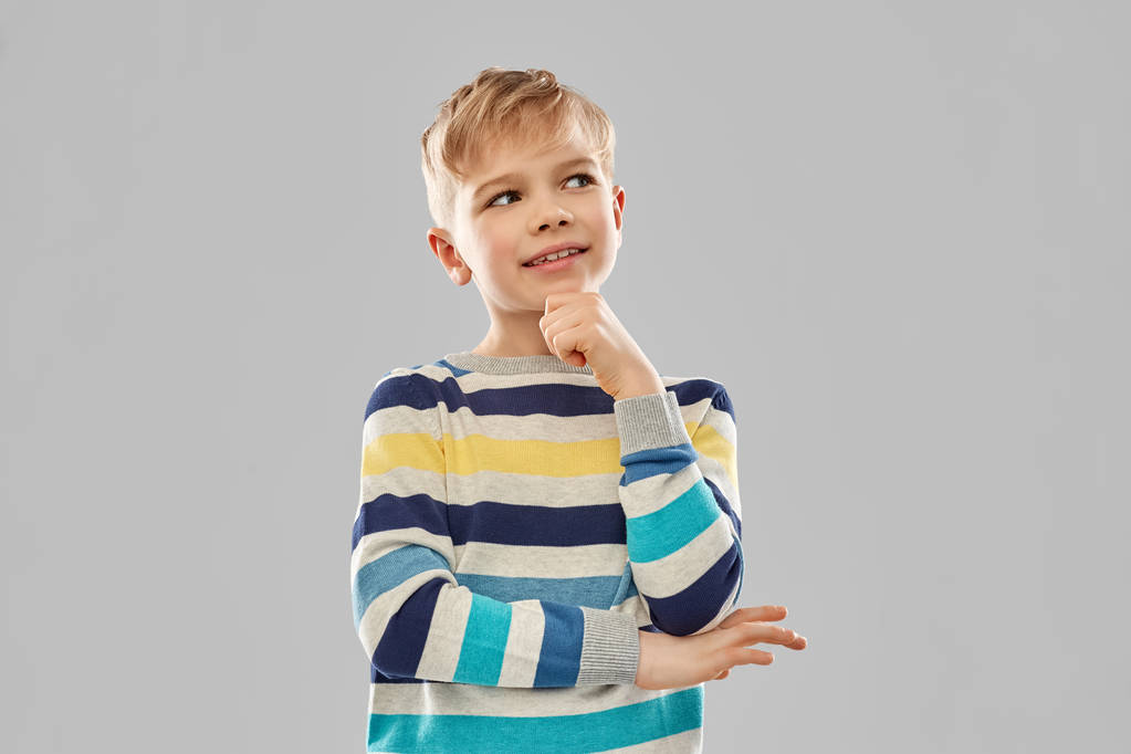 Porträt eines denkenden Jungen im gestreiften Pullover - Foto, Bild