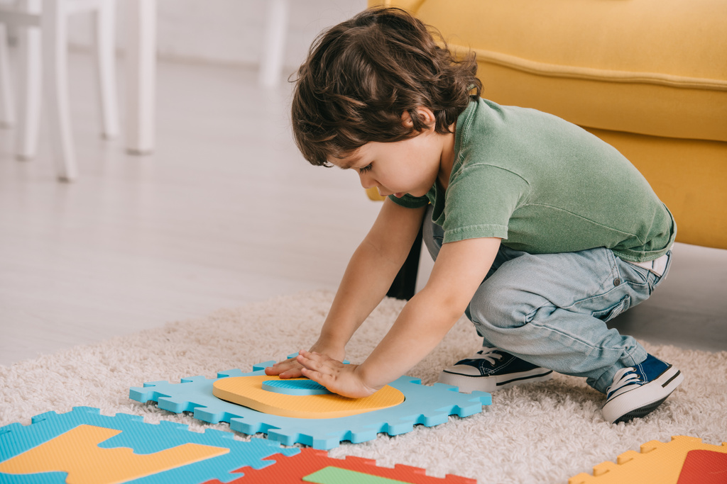 mignon enfant en t-shirt vert jouer avec tapis de puzzle
 - Photo, image