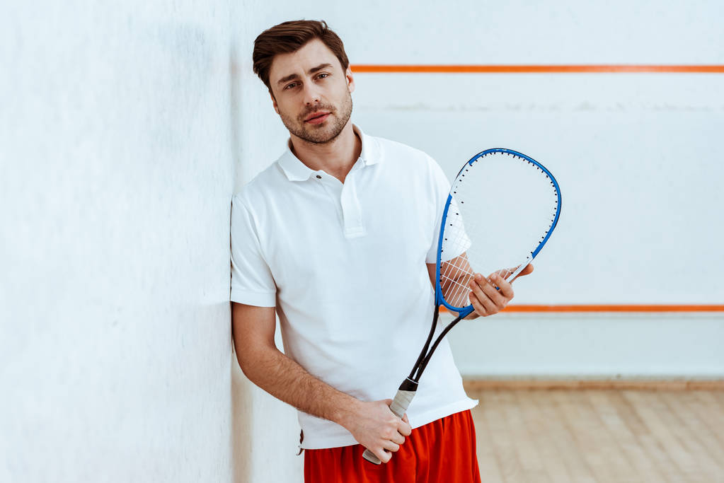 Jogador de squash barbudo segurando raquete e olhando para a câmera
 - Foto, Imagem