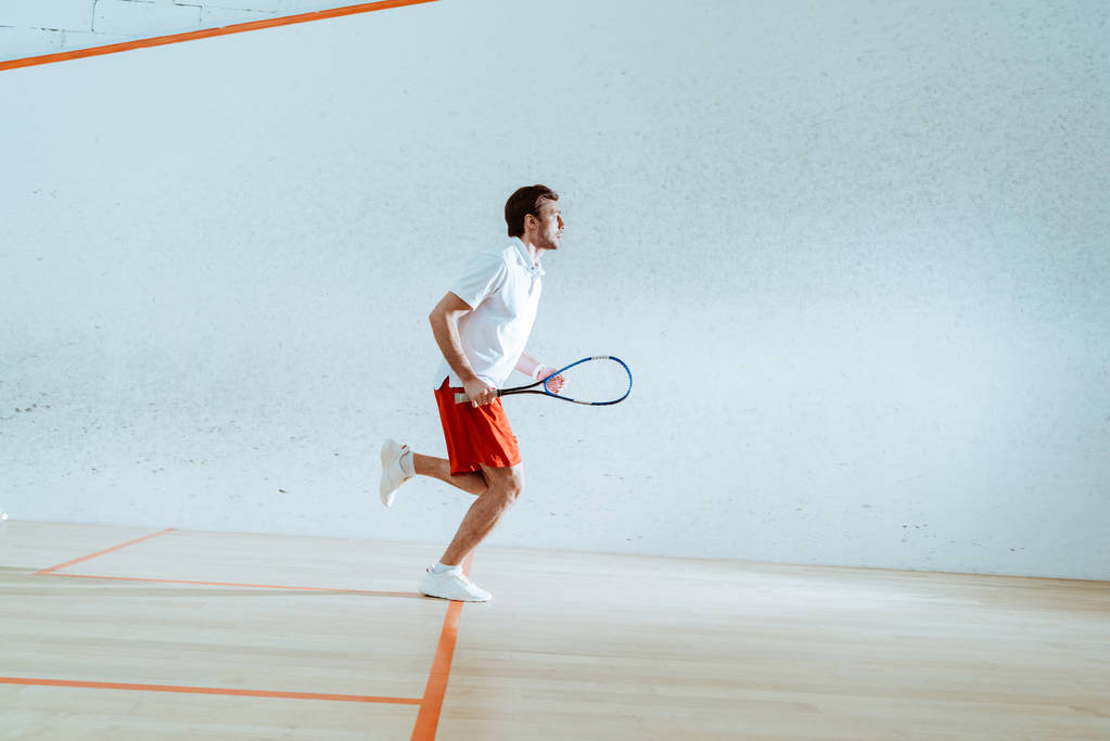 Ganzkörperansicht des Sportlers mit Schläger beim Squash-Spiel - Foto, Bild