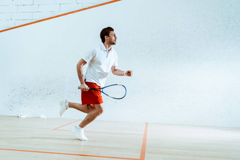 Pełny widok długości sportowca z rakieta działa podczas gry w squasha - Zdjęcie, obraz