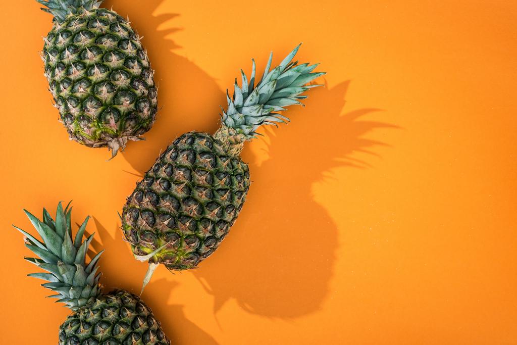ylhäältä näkyvä ananas varjoilla oranssi tausta ja kopioi tilaa
 - Valokuva, kuva