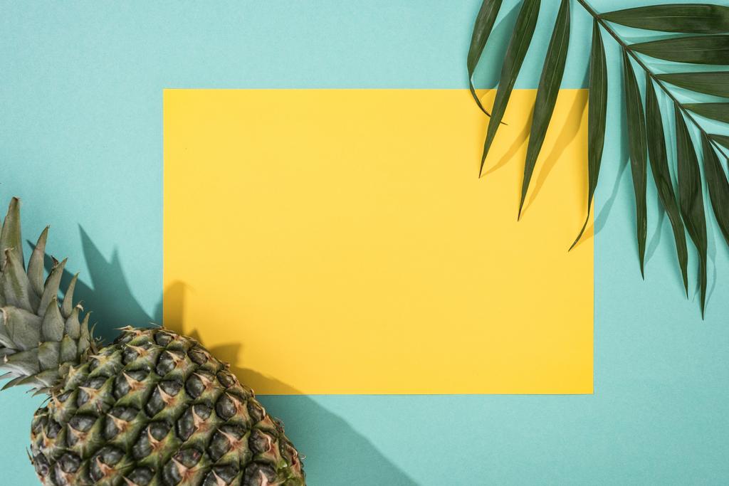 Widok z góry ananas, liść tropikalny i żółta kartka z kopią miejsca na tle turkusowym - Zdjęcie, obraz