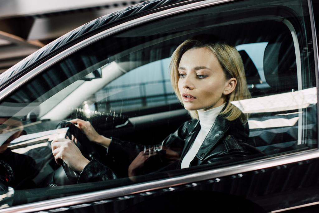 hermosa mujer rubia sosteniendo el volante mientras conduce el coche
  - Foto, imagen