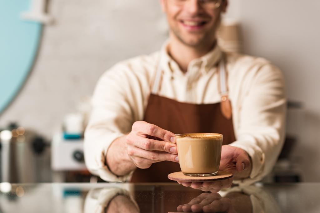 Selective focus of barista holding cup of coffee - Photo, Image